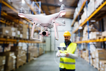 A Man flying a drone in a warehouse