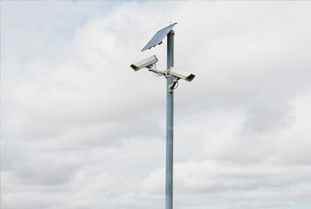 A pole with a Solar Panel and two bullet cameras