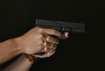 a side angle of someone aiming a gun