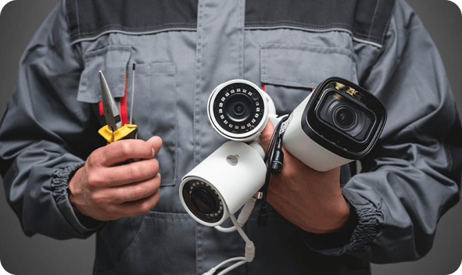 A handyman holding multiple cameras and tools to start the software integration process